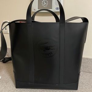 Large black Lacoste with strap.   Slightly Used minimal marks. Zipper inside.